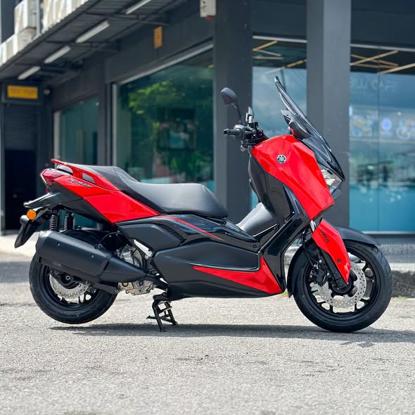 Yamaha XMAX 250 full side profile in red parked on asphalt