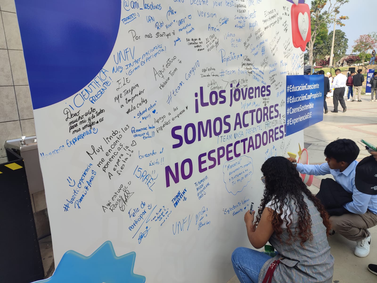 Voluntarios escribiendo en el mural de mensajes