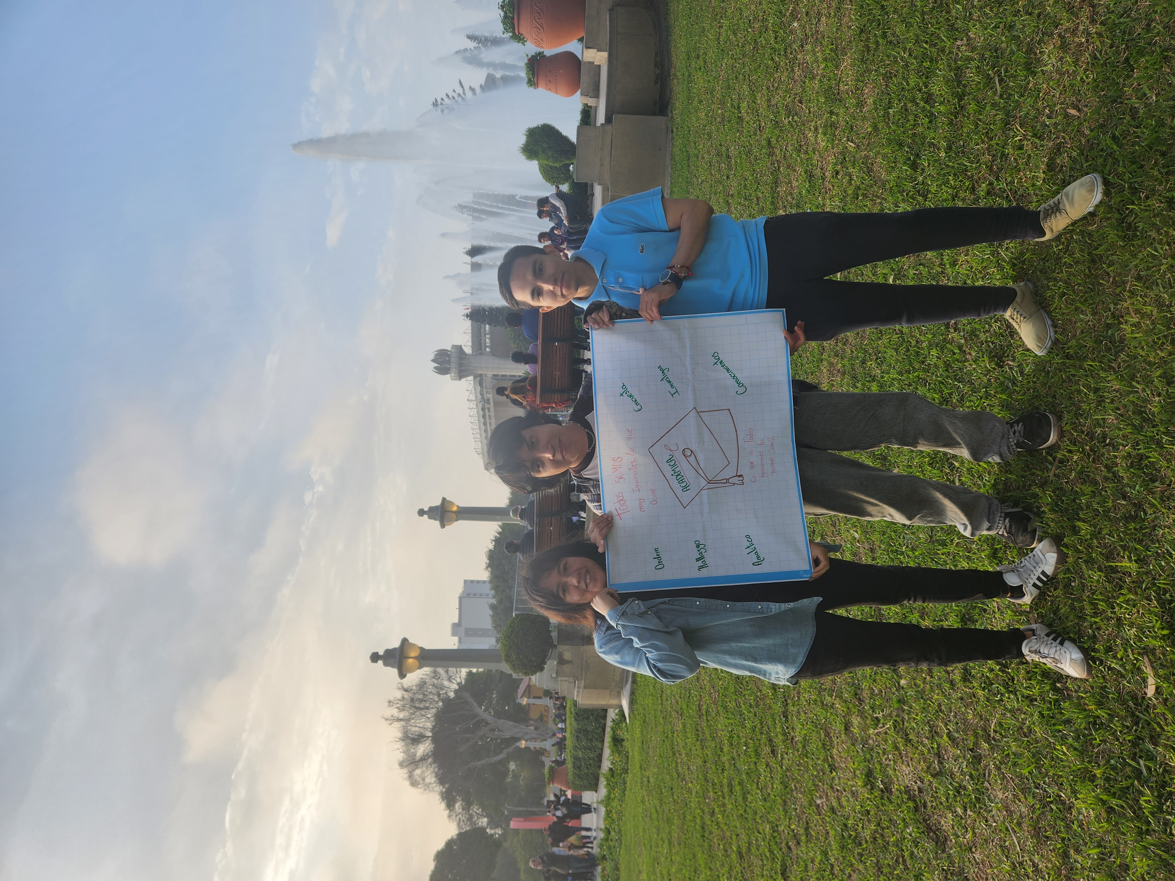 Voluntarios con afiche de trabajo académico en el parque