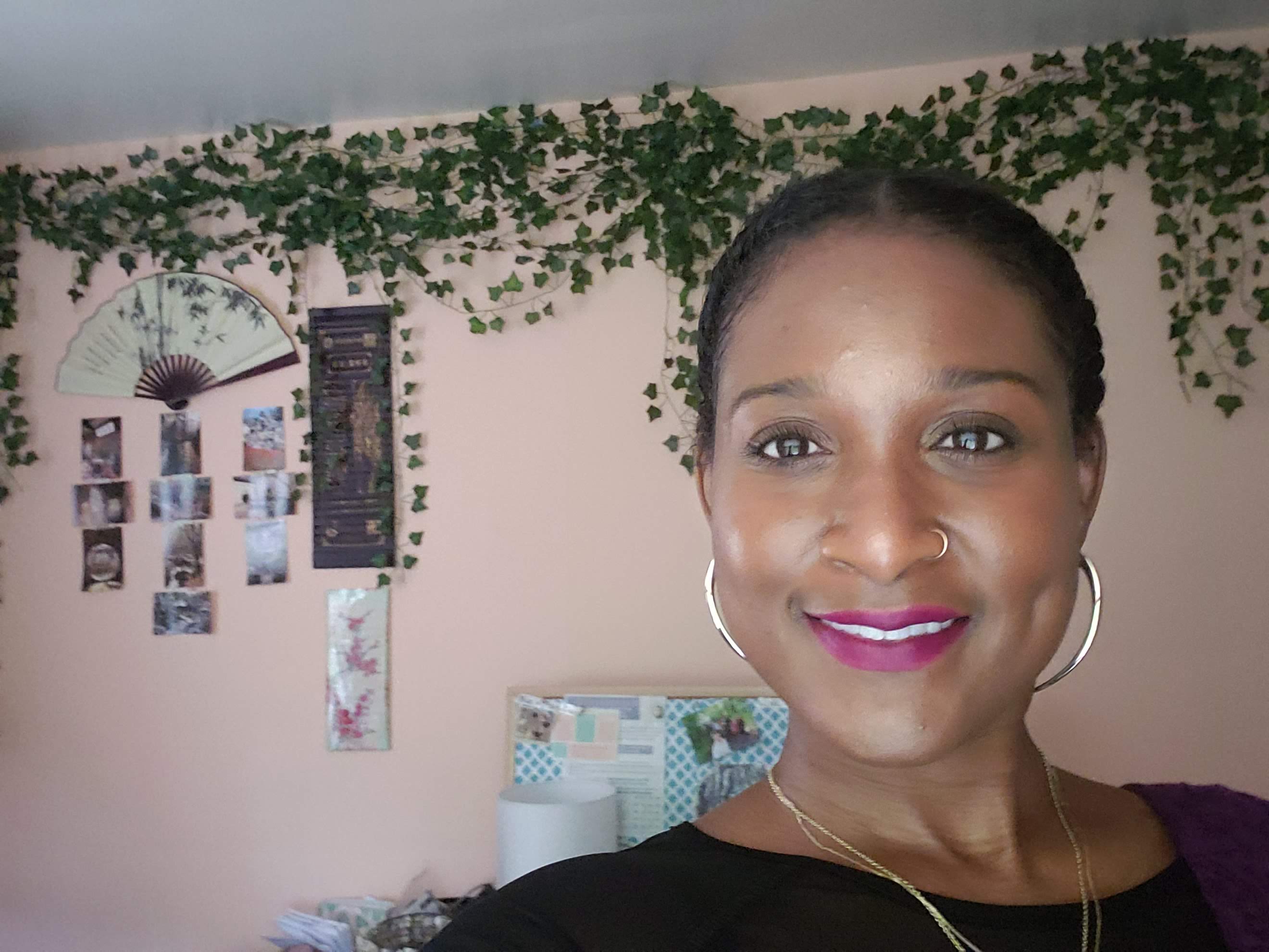 Queen Mercy smiling warmly, surrounded by cascading ivy, at home in her full humanity
