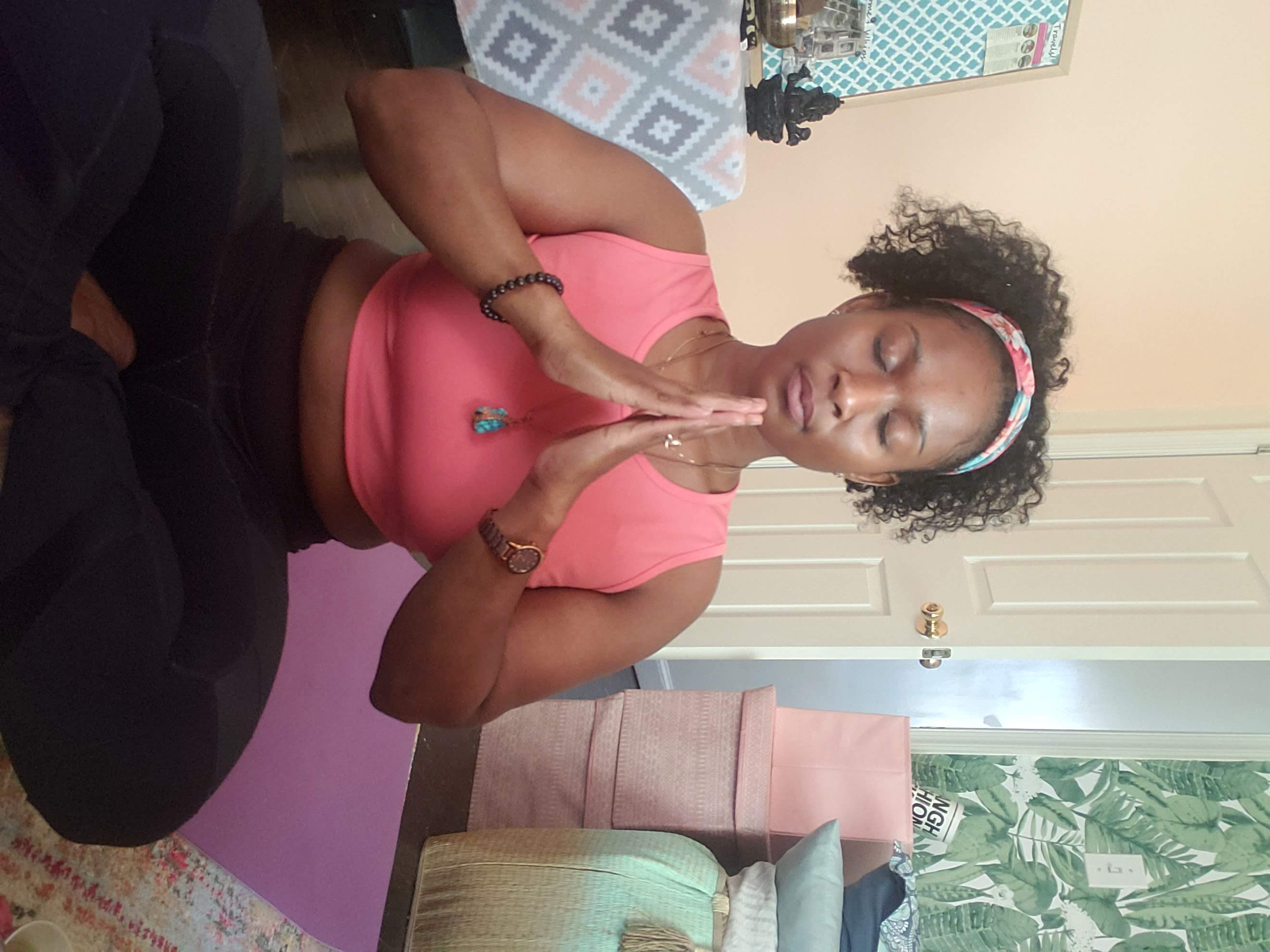 Queen Mercy seated in lotus pose with hands in prayer position, embodying meditation and peace