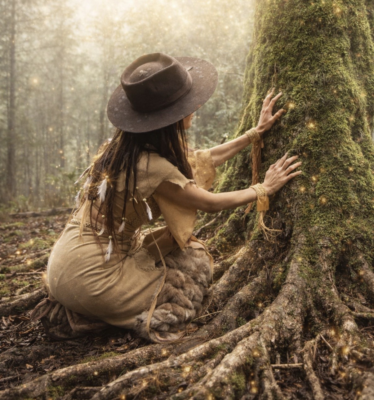 A woman kneeling before a moss-covered tree