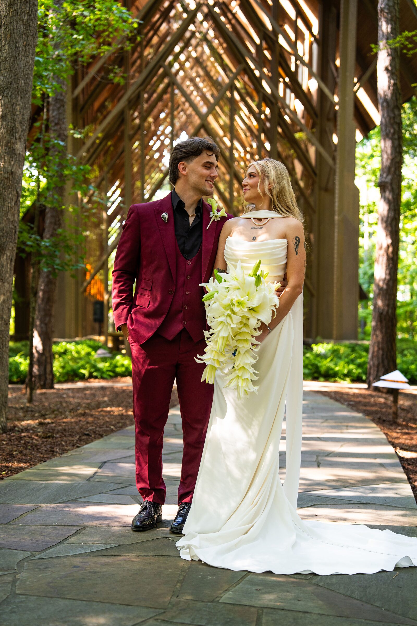Bride and groom smiling at each other on a stone path at Garvan Woodland Gardens, Hot Springs, Arkansas