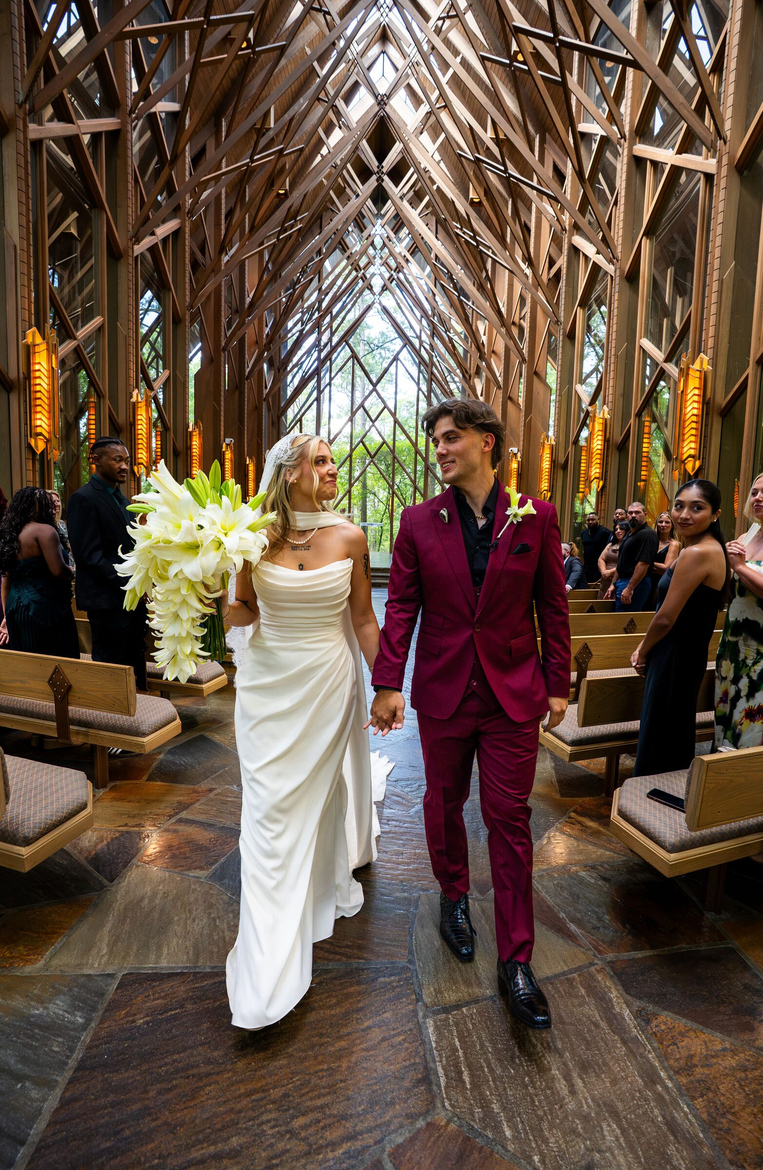 Bride and groom walking hand in hand down the aisle after their ceremony at Garvan Woodland Gardens, Hot Springs, Arkansas