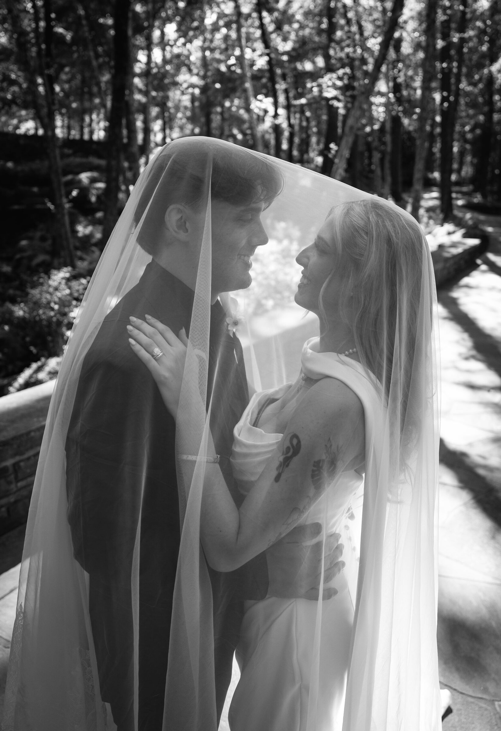 Black and white portrait of the couple beneath the bridal veil at Garvan Woodland Gardens, Hot Springs, Arkansas