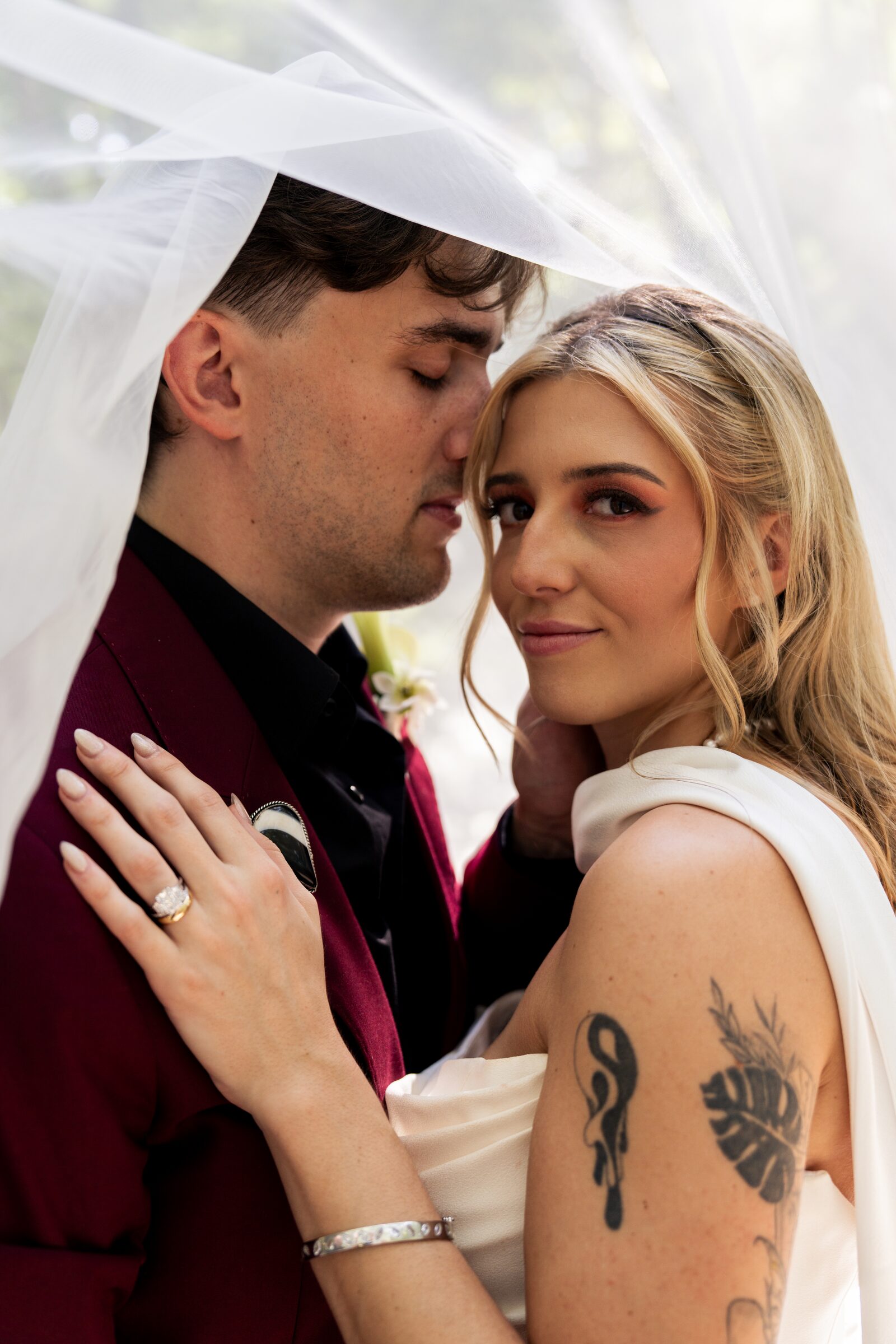 Bride and groom in an intimate embrace beneath the veil at Garvan Woodland Gardens, Hot Springs, Arkansas