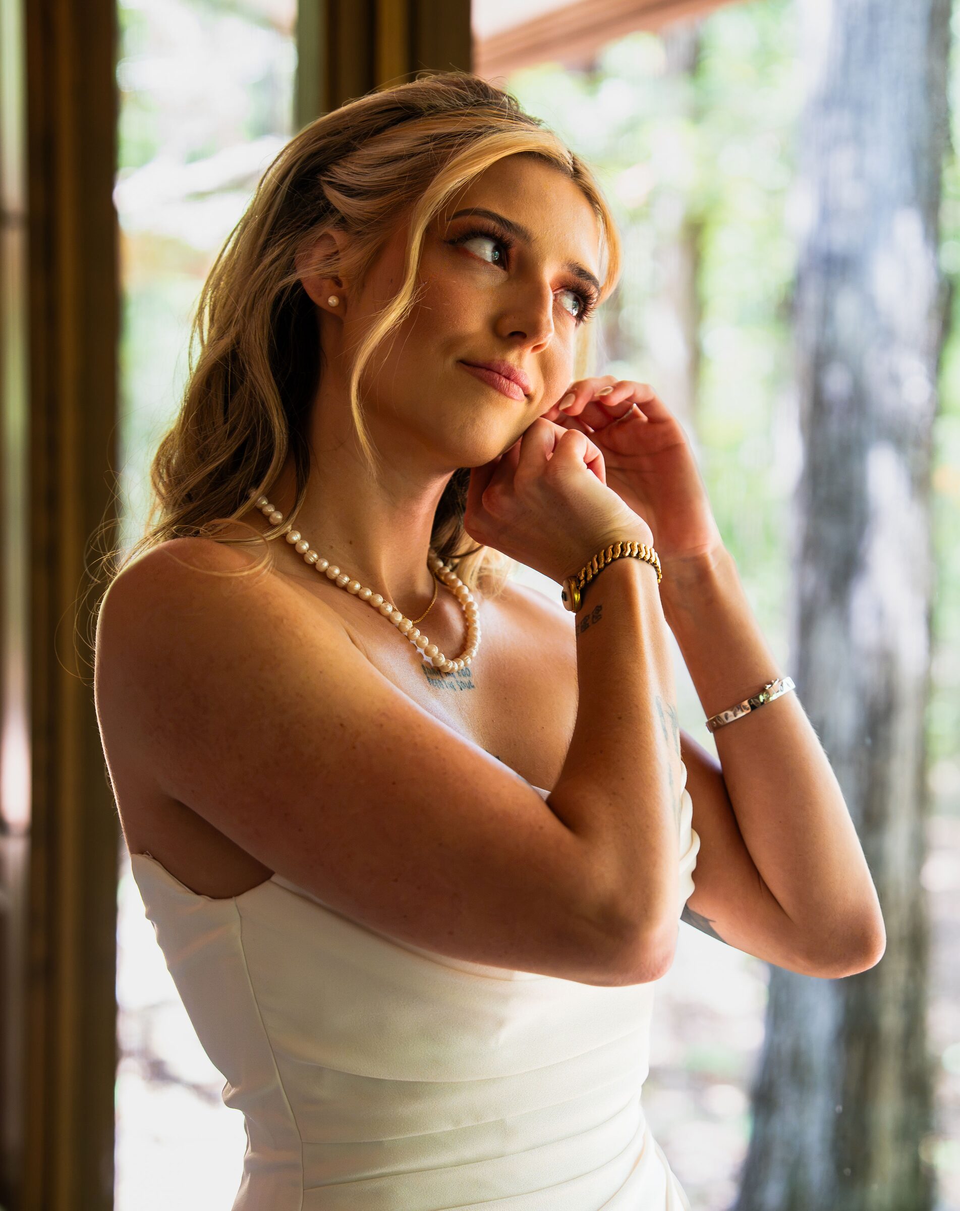 Bride adjusting her pearl earring inside the chapel