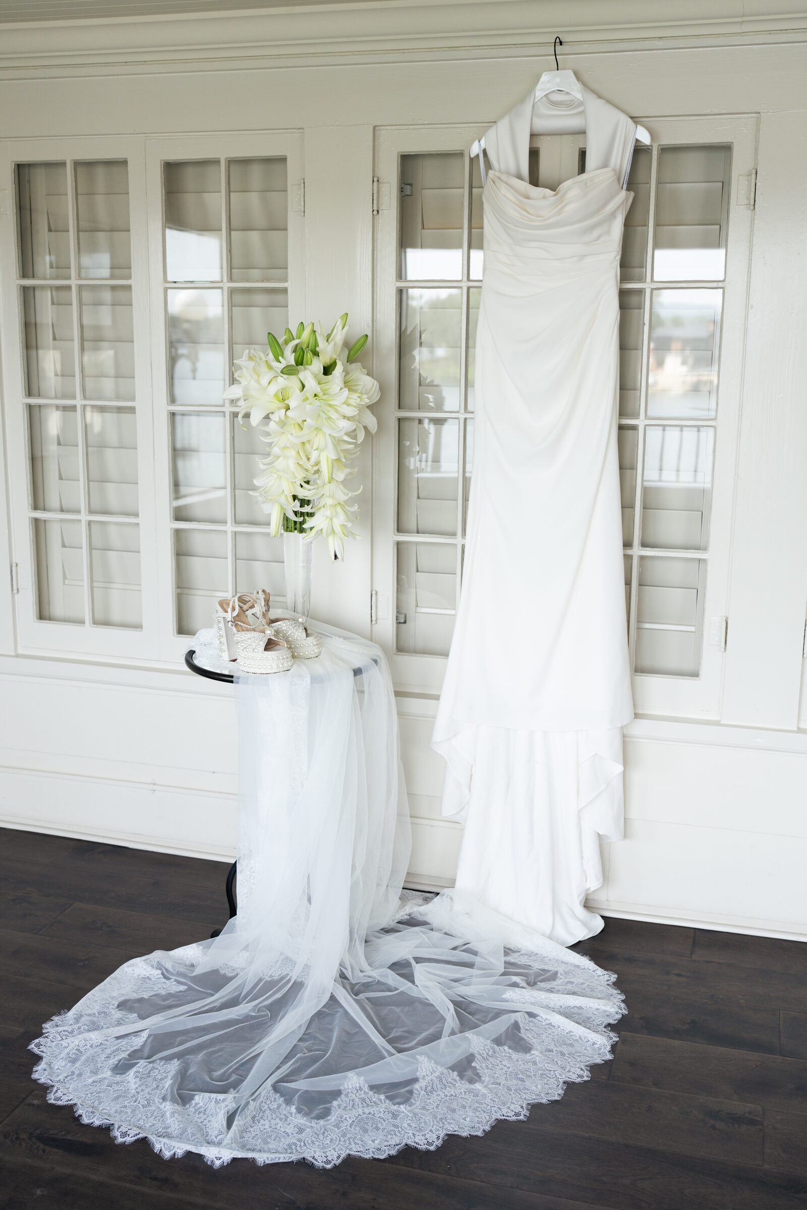 Wedding dress on a hanger beside a veil and lilies at Garvan Woodland Gardens, Hot Springs, Arkansas