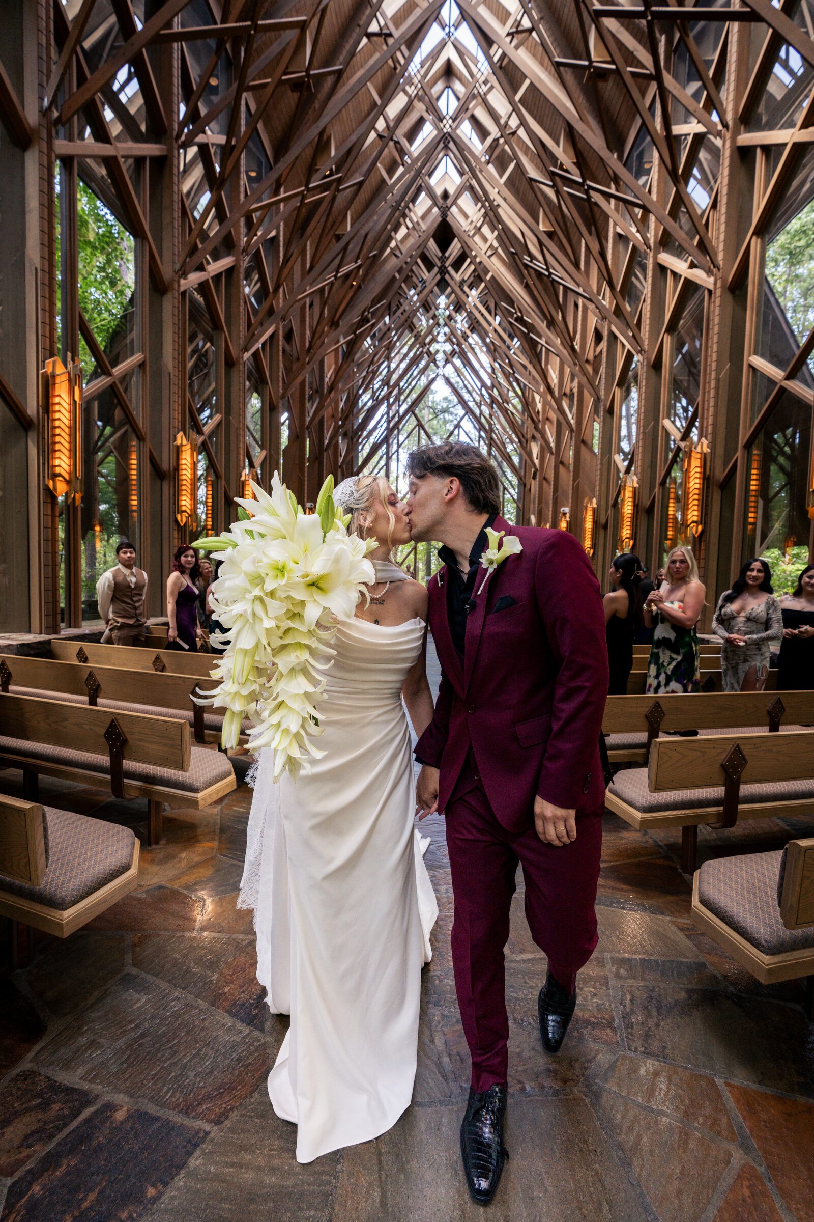 Bride and groom kissing as they walk down the aisle after their ceremony