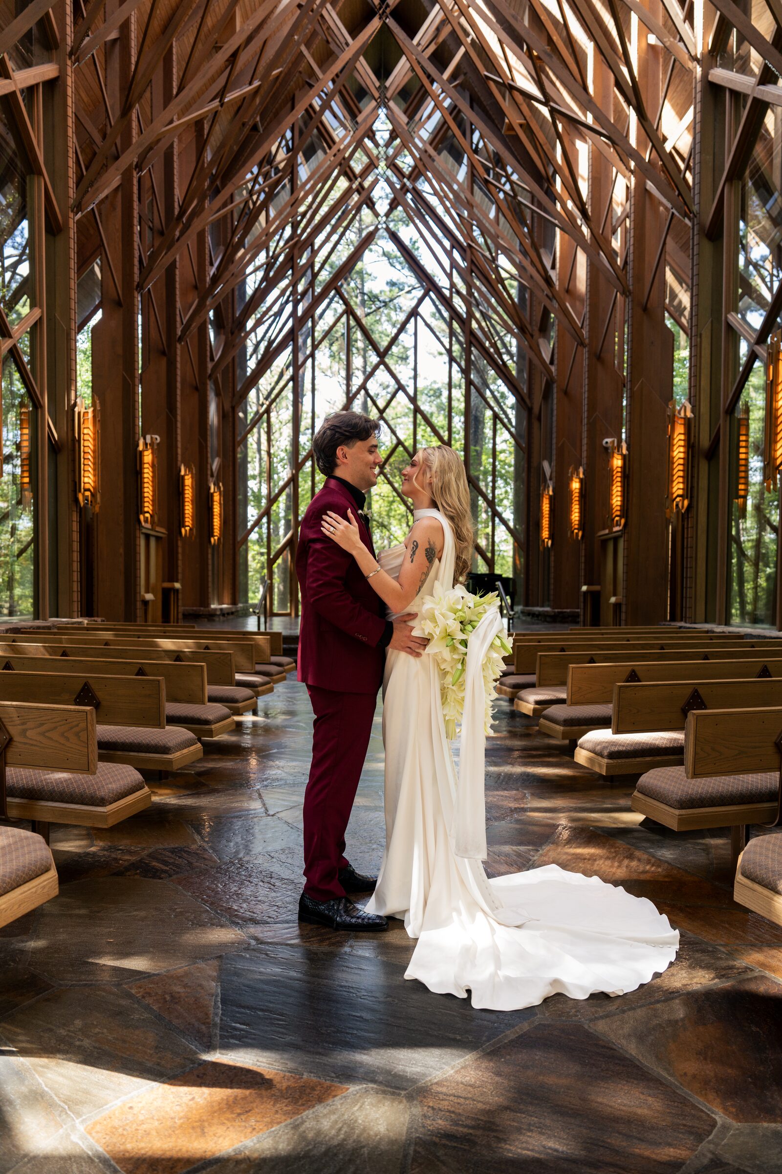 Bride and groom facing each other with a lily bouquet inside the chapel at Garvan Woodland Gardens, Hot Springs, Arkansas