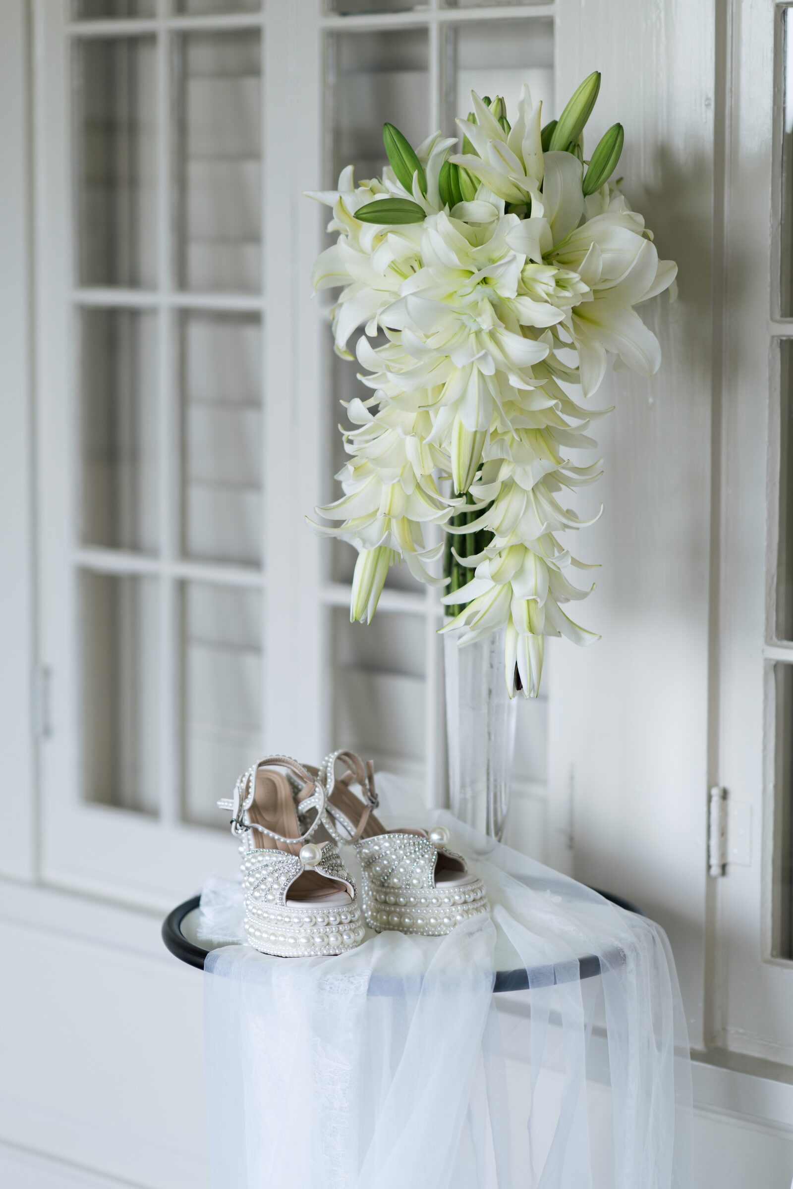 Bridal bouquet and pearl heels on a stone table at Garvan Woodland Gardens, Hot Springs, Arkansas