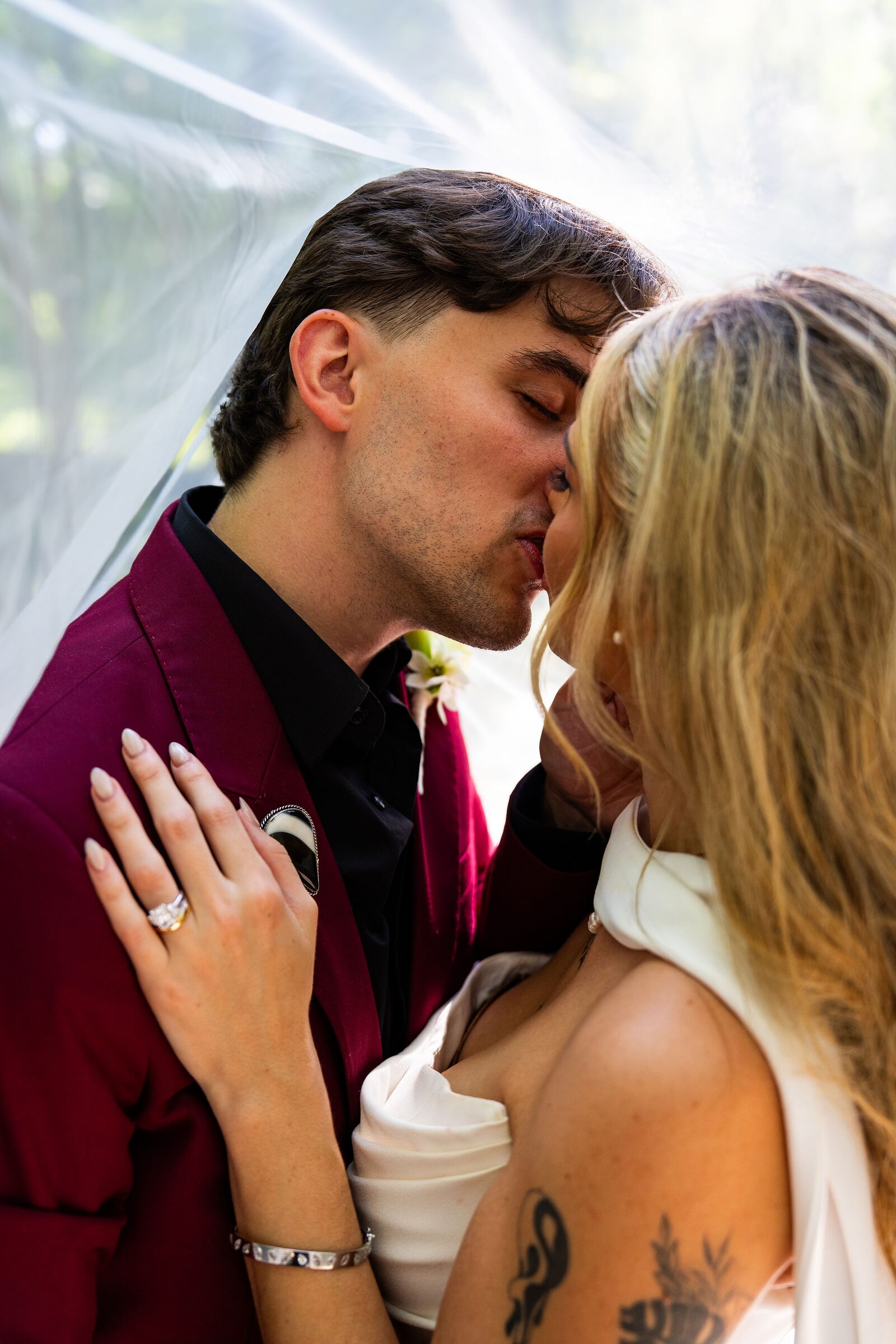 Bride and groom kissing beneath the veil at Garvan Woodland Gardens, Hot Springs, Arkansas