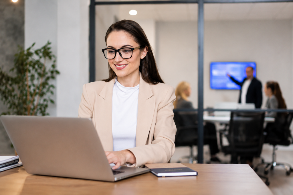Professional woman working on a laptop in a bright modern office