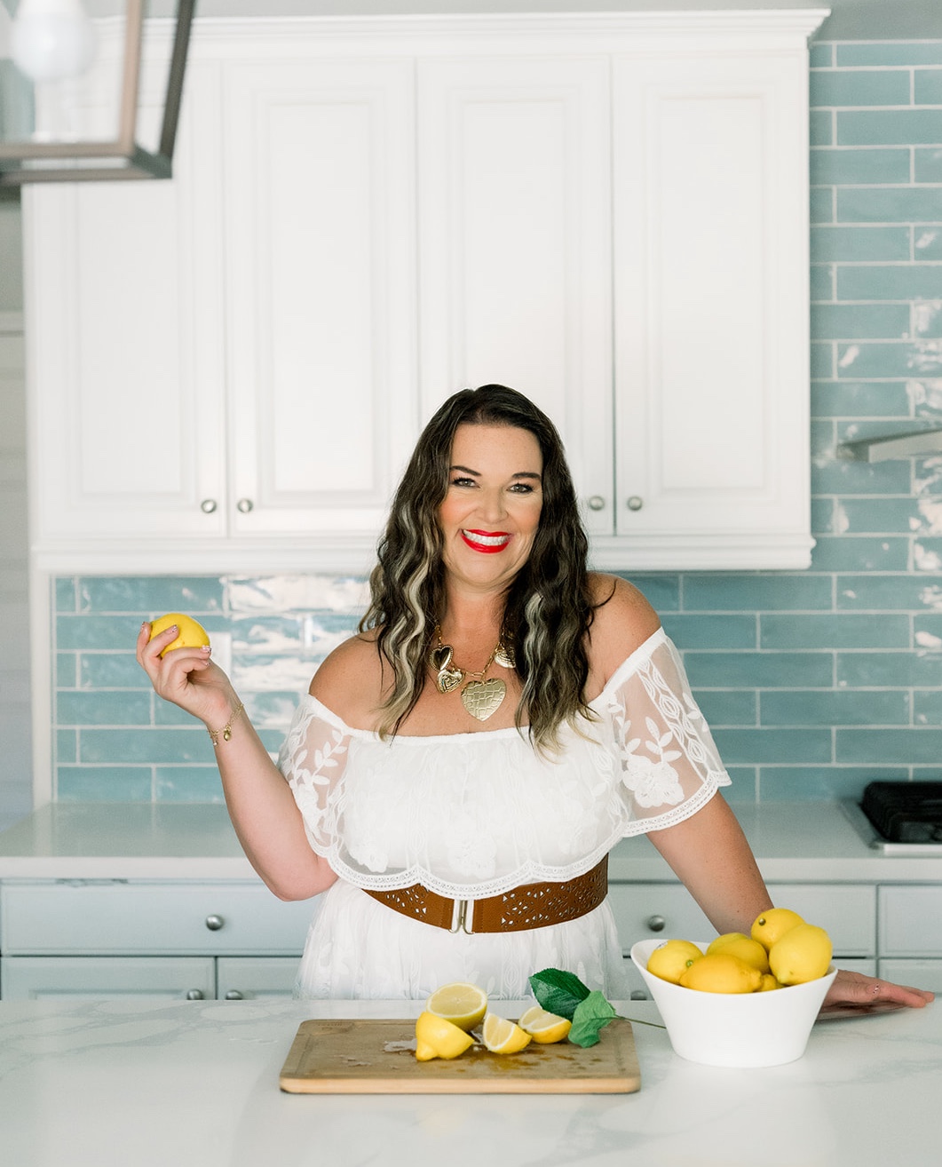 Client holding a lemon in a bright kitchen during a content branding session
