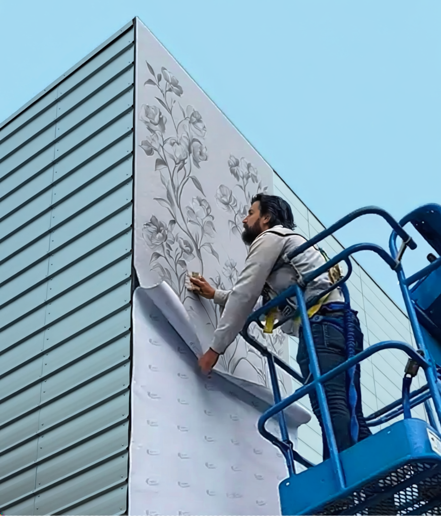 M&P painter installing a custom 3M floral wall mural on a commercial building exterior in Calgary, AB