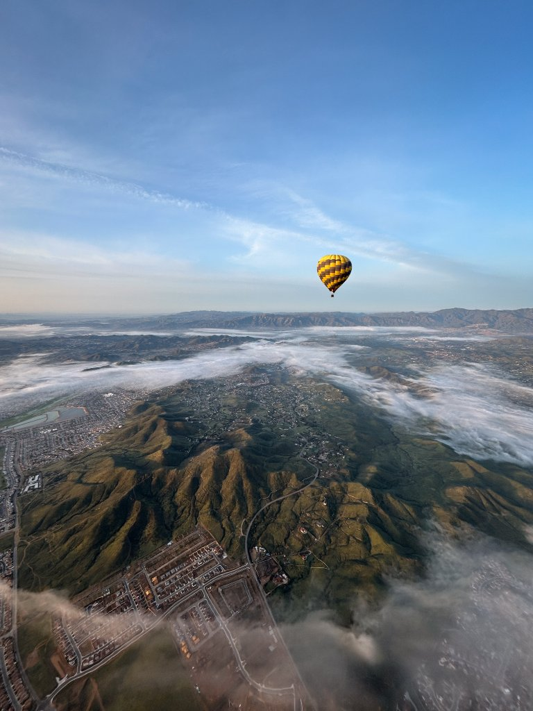 Balloon above clouds and mountains