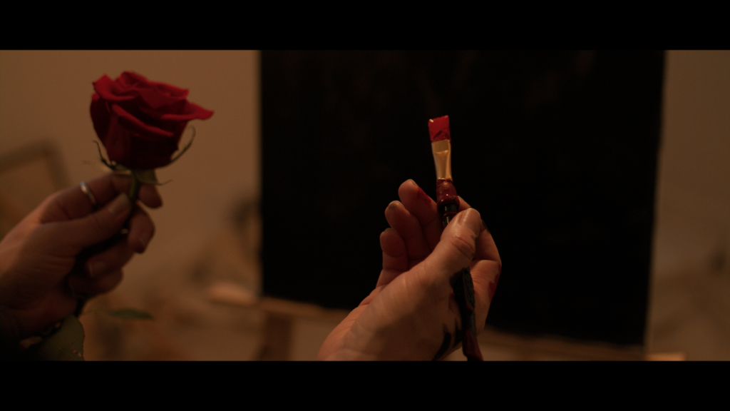Palette of Dreams still of a rose and a paintbrush held in matching hands