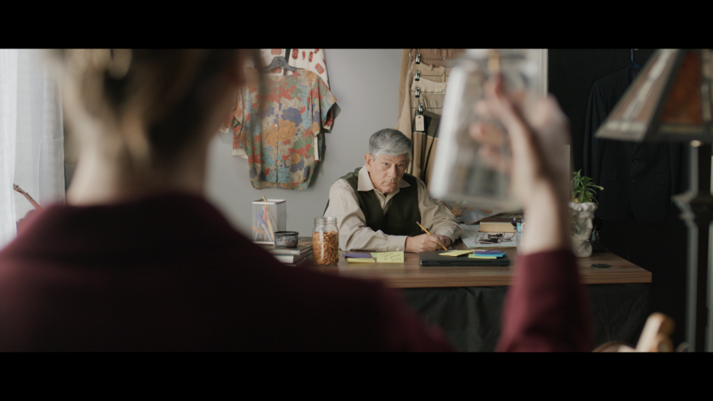 Palette of Dreams still of a character facing an older man across a desk