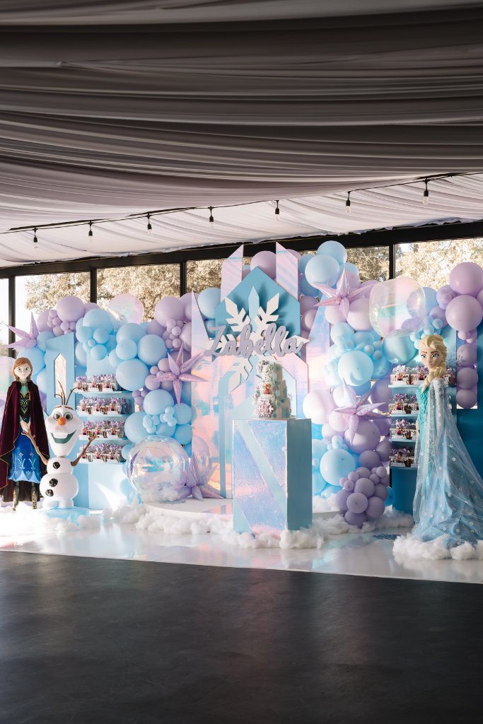 Frozen themed celebration setup with Elsa backdrop and balloon garland