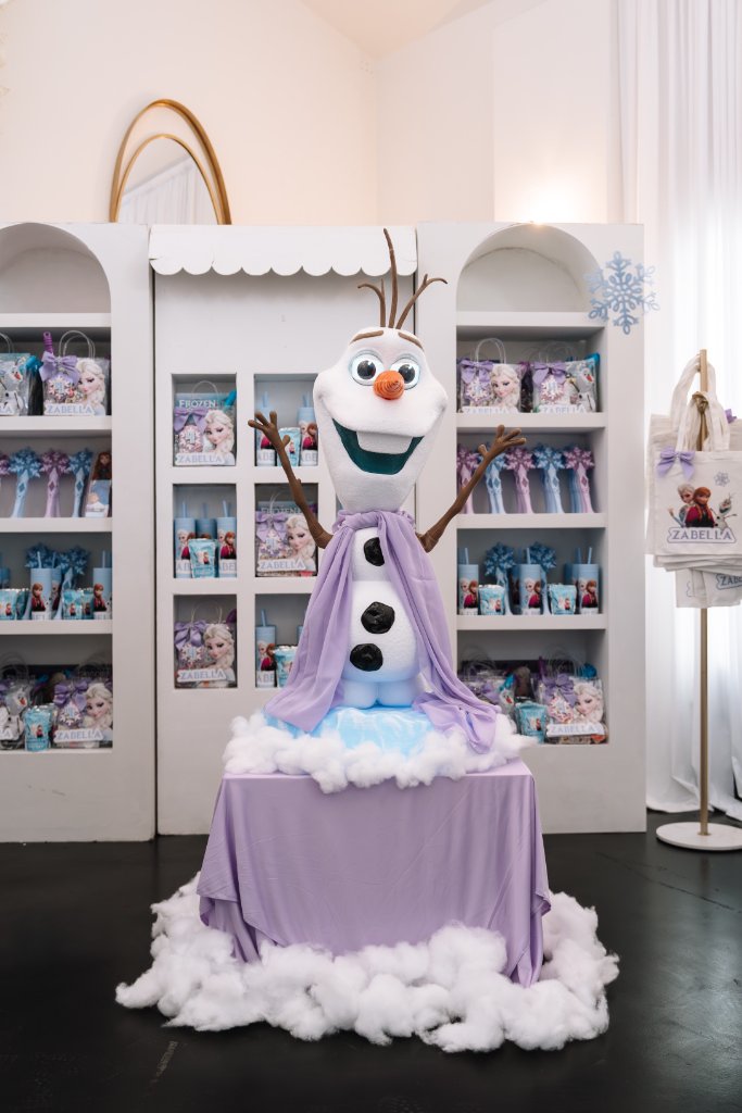 Girl in Elsa costume posing at Frozen themed decor backdrop