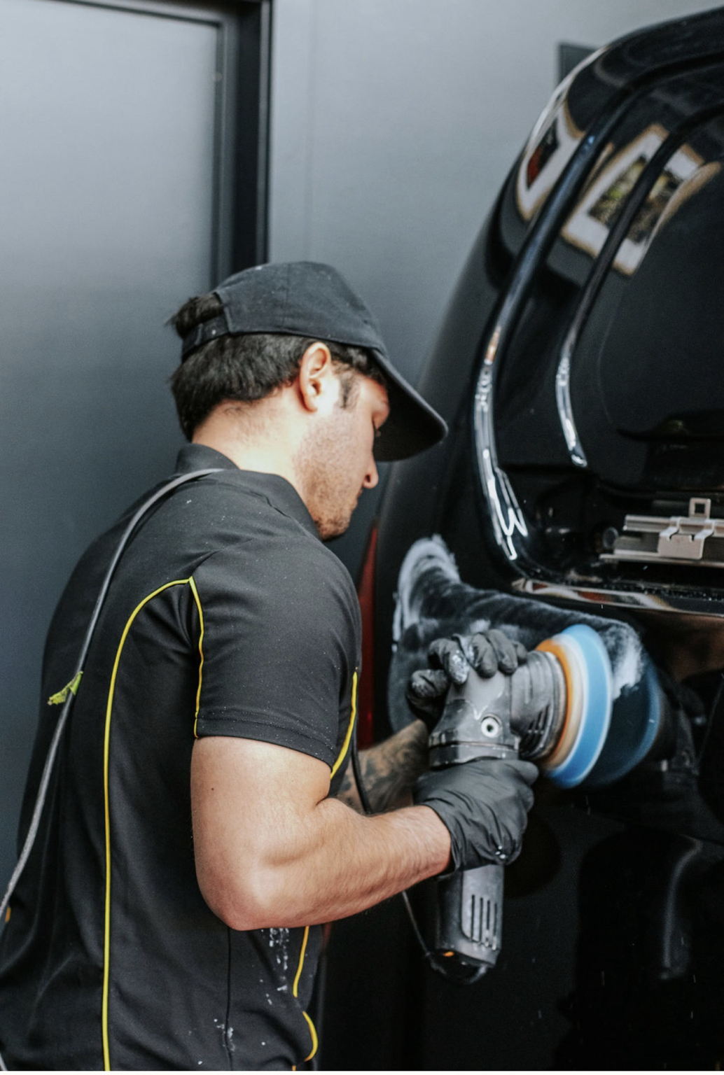 Machine paint correction on a black vehicle under studio lighting