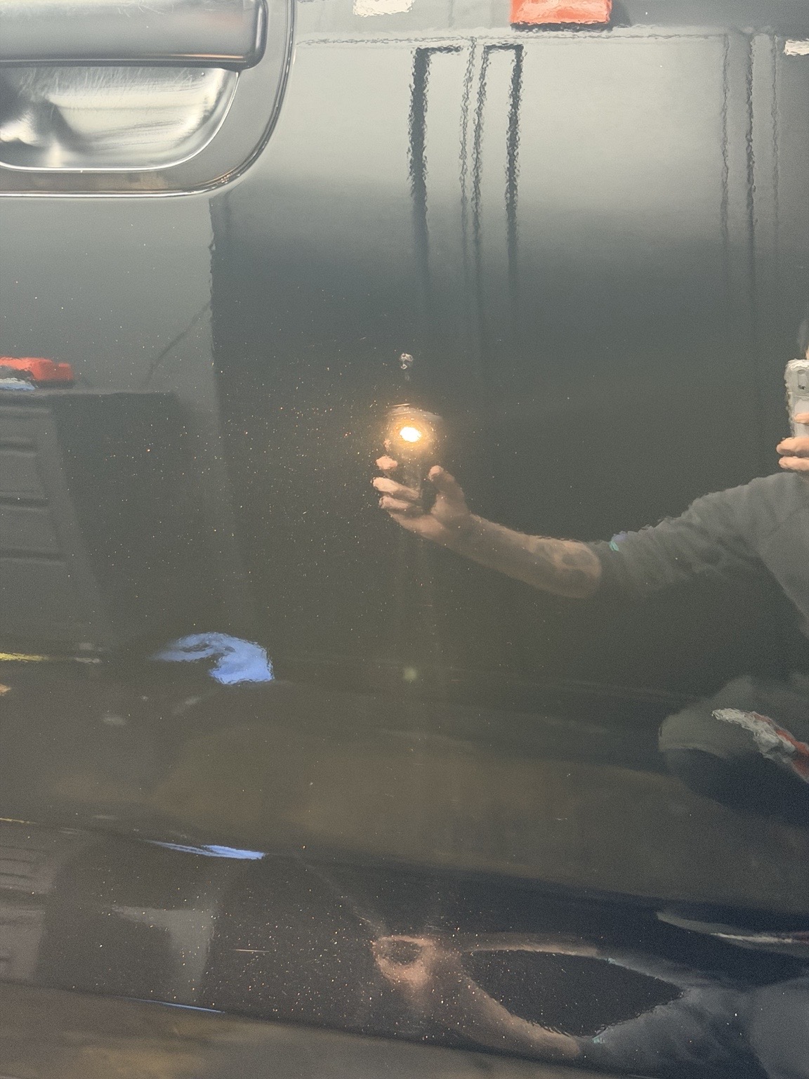 Paint inspection under hand-held studio lighting inside the Forza Auto Studio