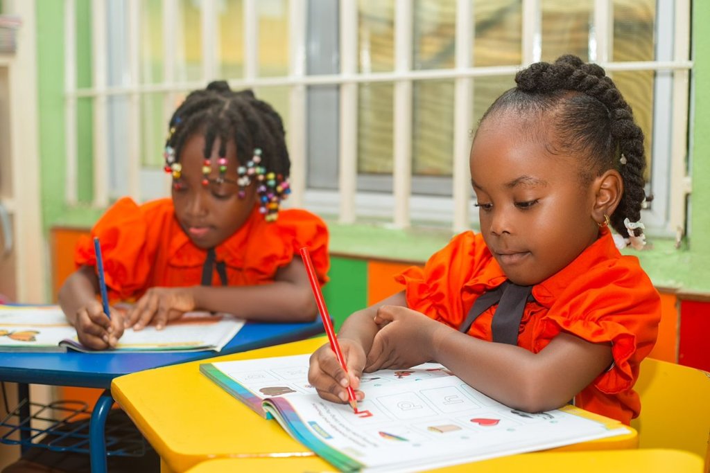 Girls writing at colourful desks