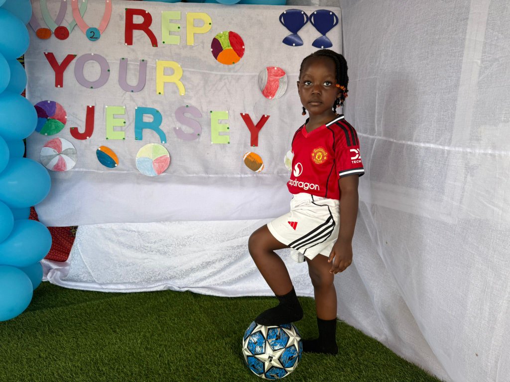 Child in jersey posing with football