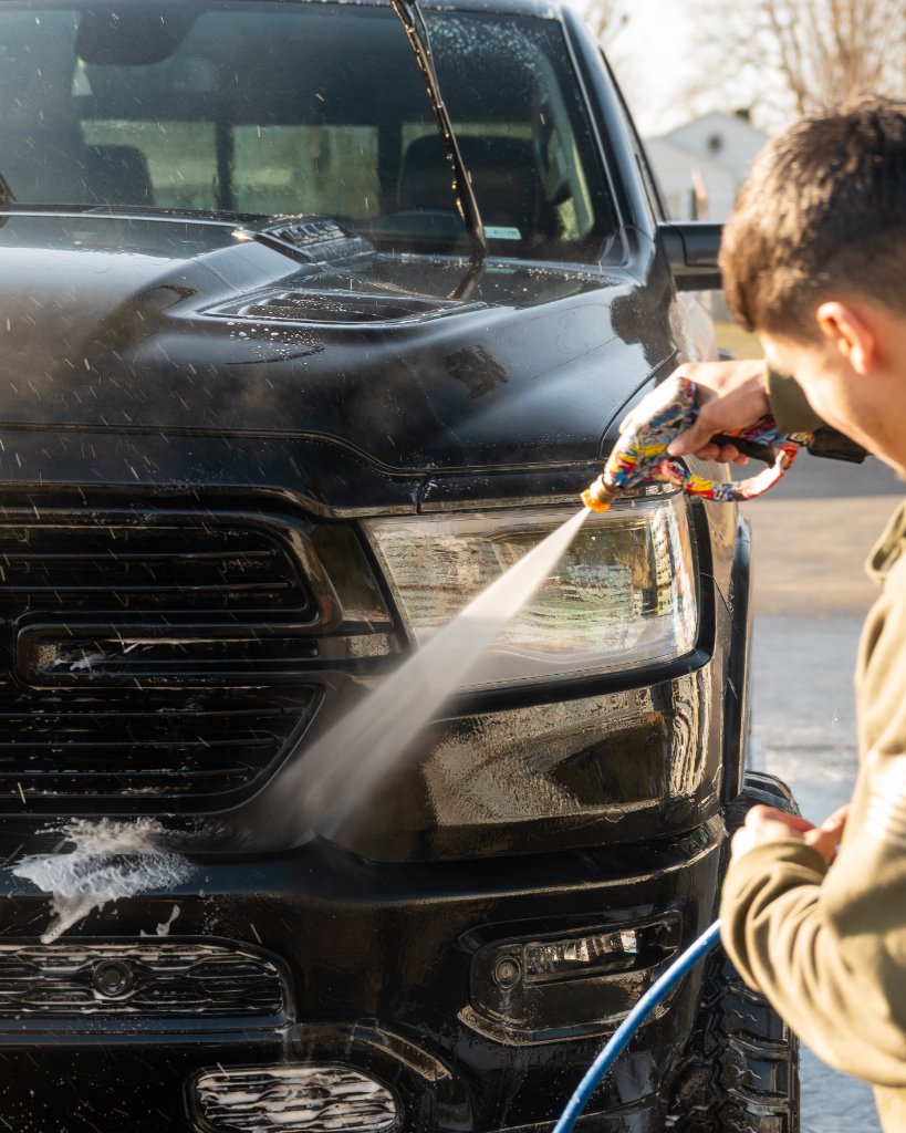 Tech pressure washing black truck headlight