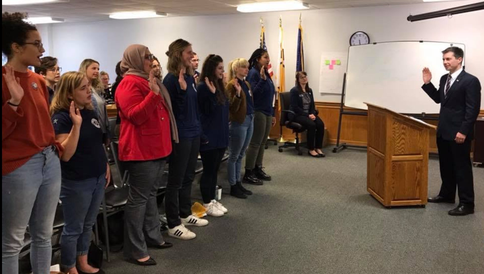 Mayor Pete Buttigieg administers the AmeriCorps pledge to a room of new members