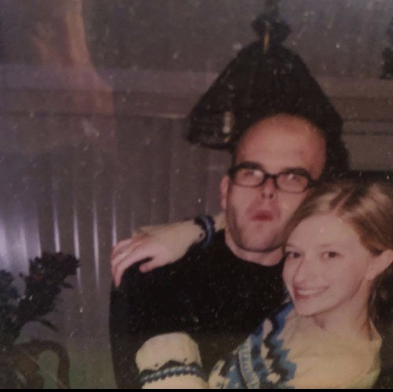 A man in glasses with a young woman leaning close