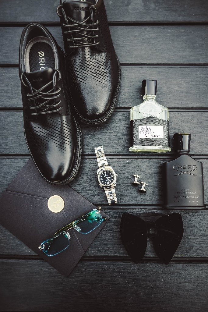 Groom details flat lay with dress shoes, cologne, watch and cufflinks
