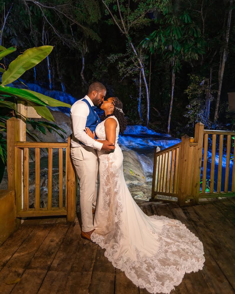 Couple kissing beside waterfall at night