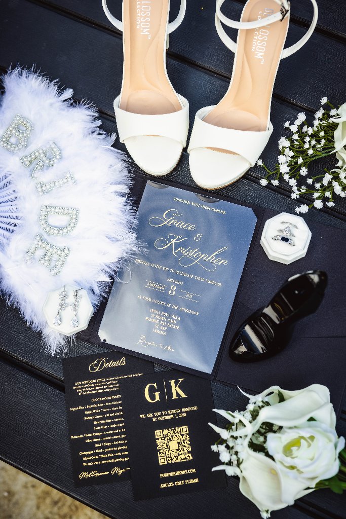 Wedding flat lay with bridal heels, invitation suite, and white florals