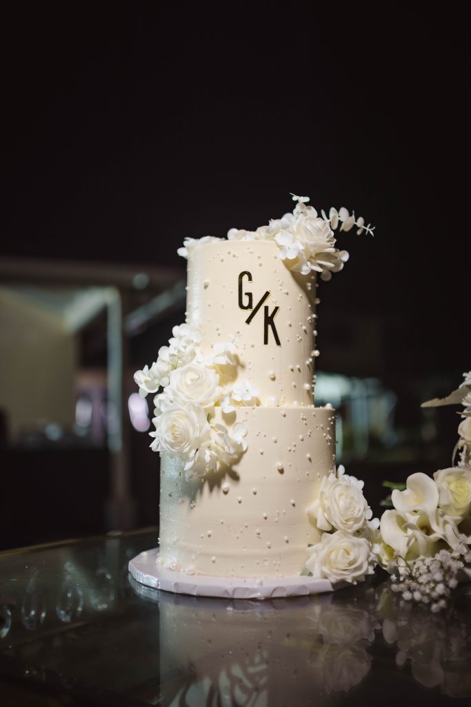 Luxury white wedding cake with initials and white flowers