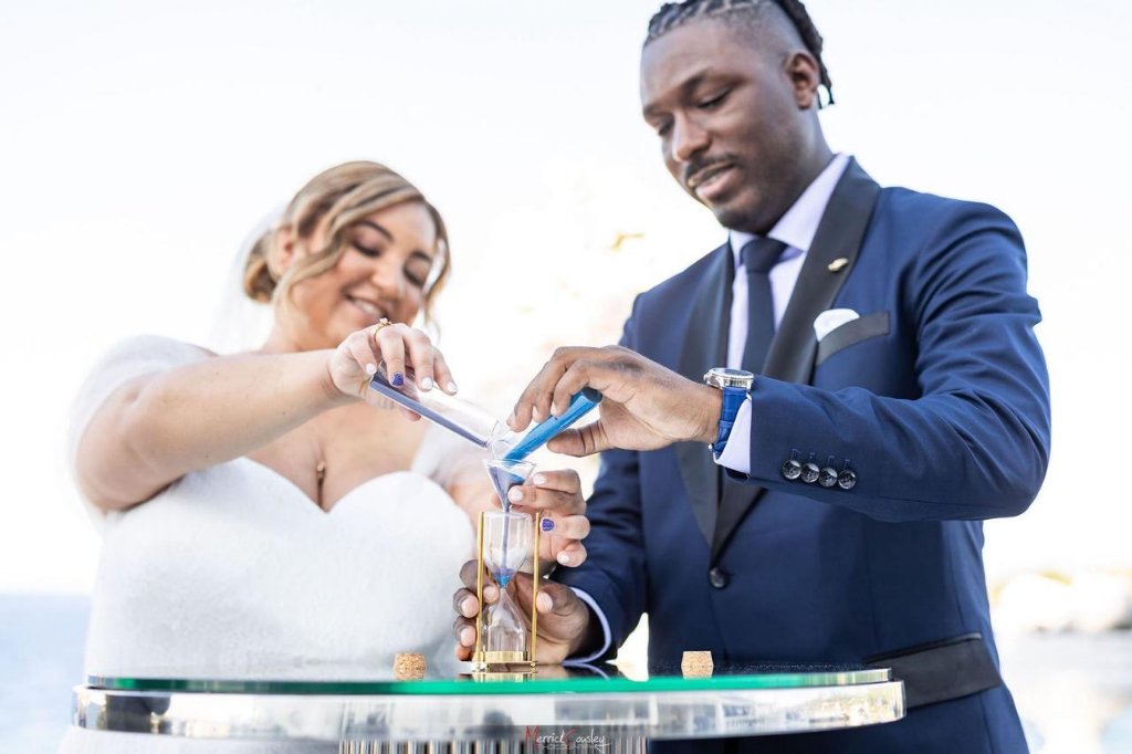 Close-up of couple pouring coloured sand together in unity ceremony