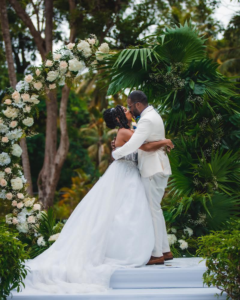 Ceremony first kiss under floral arch
