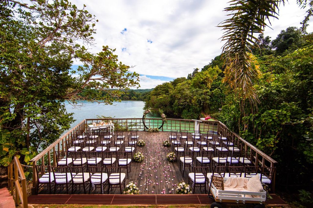 Higher elevated angle of ceremony deck framed by tropical trees with turquoise San San Bay behind