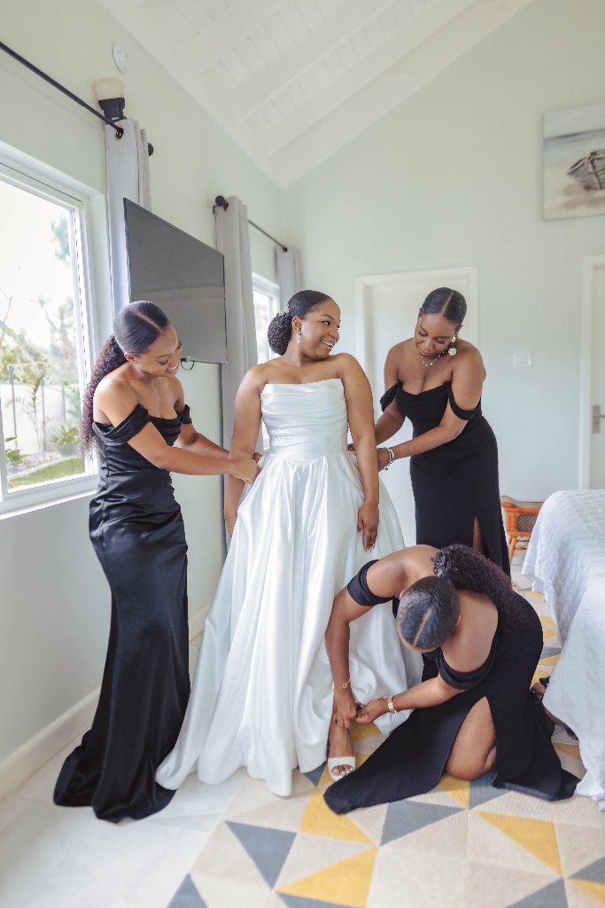 Bride in white dress with bridesmaids during getting ready