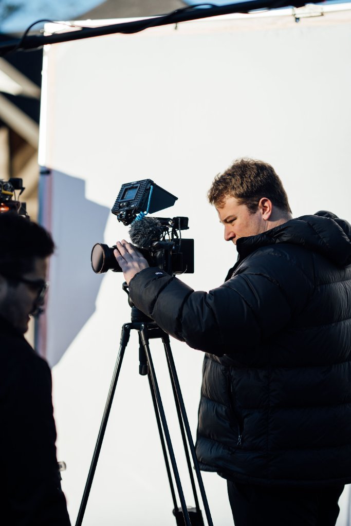 McCoy Visuals cinematographer adjusting camera settings during a brand video production shoot