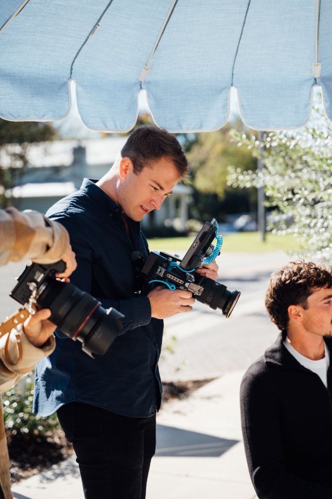 McCoy Visuals cinematographer adjusting camera settings during a brand video production shoot