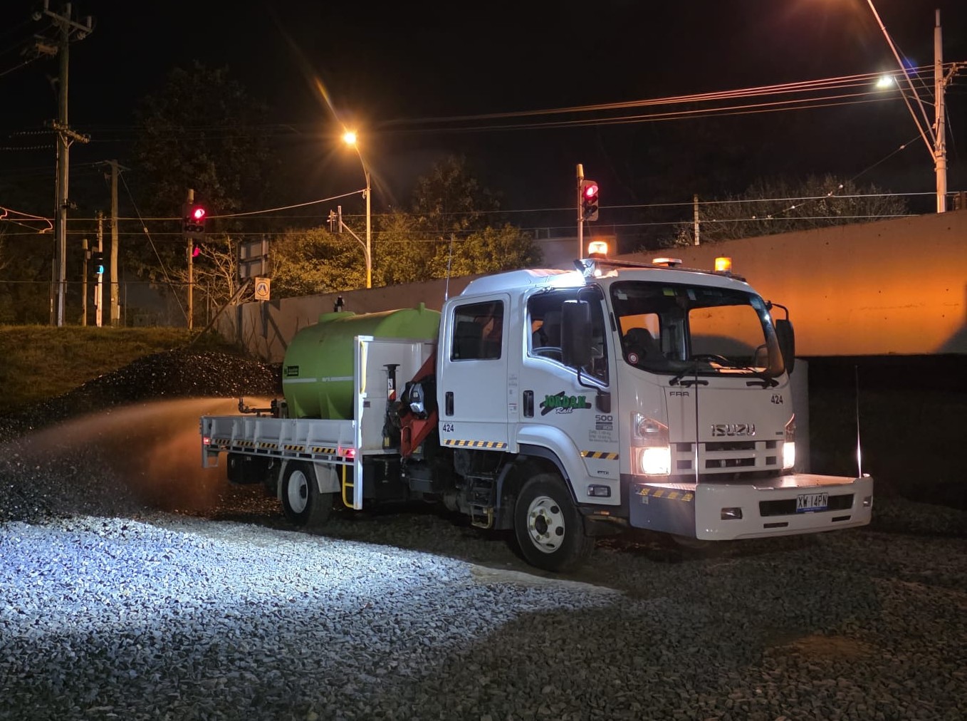 Hi-rail truck with 4,000L tank and spray equipment watering ballast at night