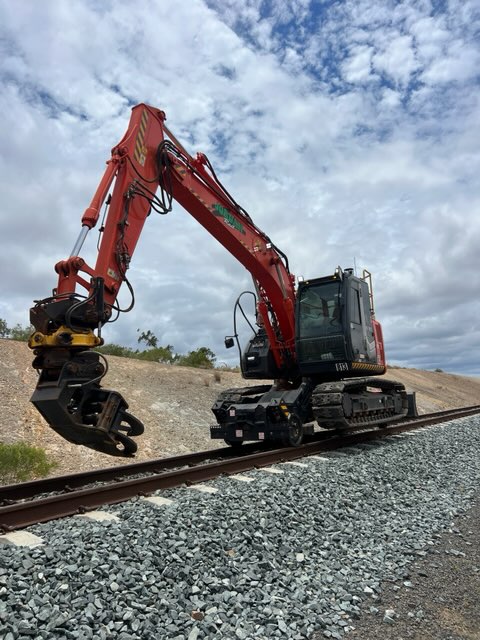 Hi-rail excavator with grapple on track