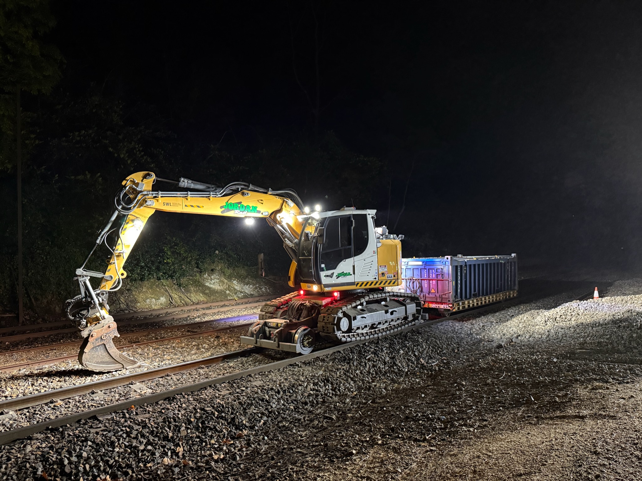 Hi-Rail excavator towing a demountable flocon container on a rail trailer