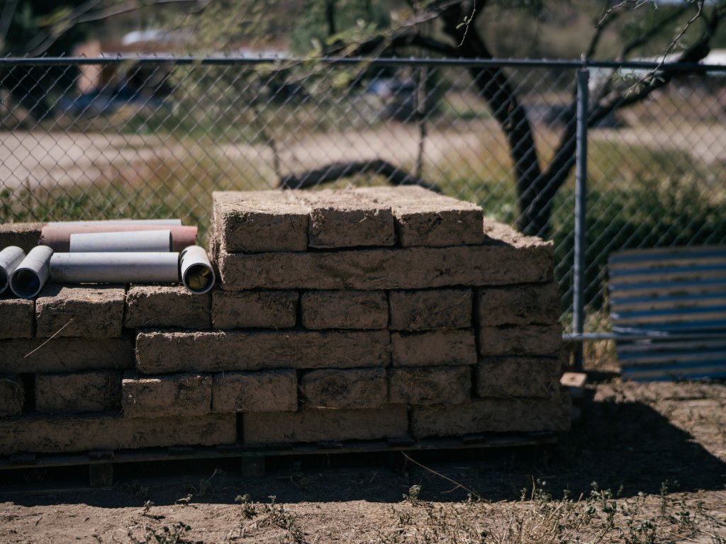 Fully cured adobe bricks stacked in a pallet at the brickyard