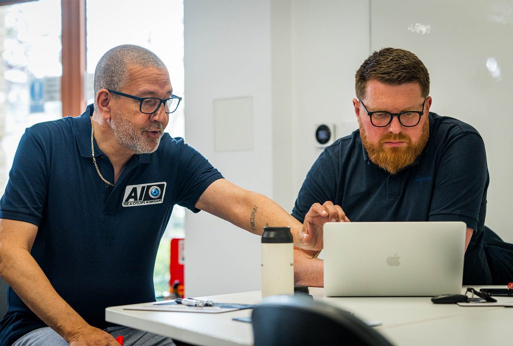 Trainers helping attendee on laptop