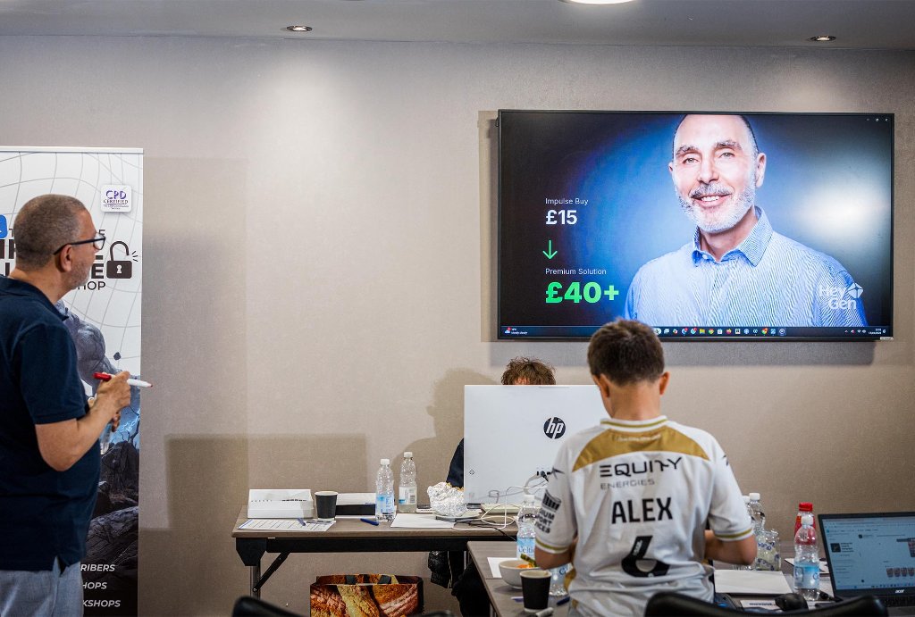 Two attendees working on AI task at laptop