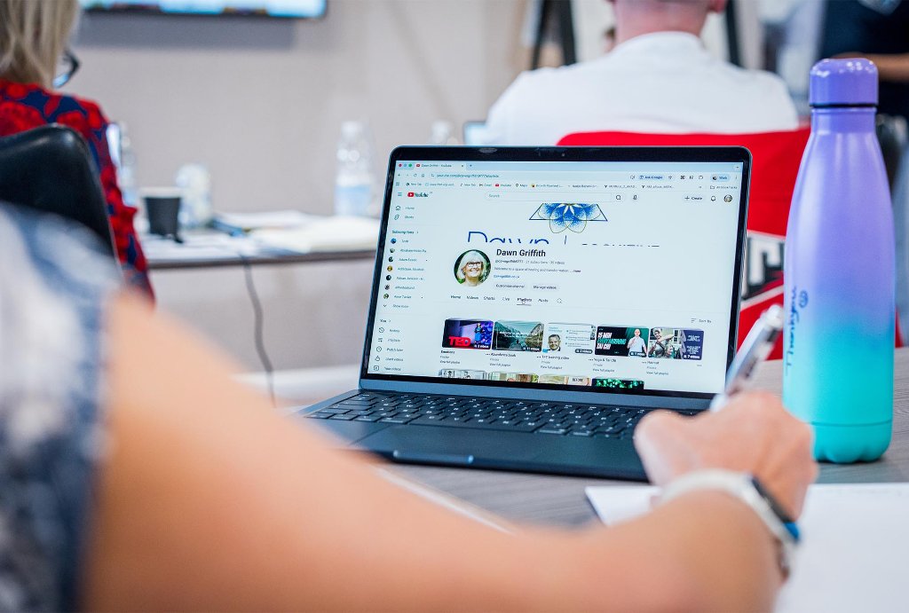 Two attendees focused together on laptop