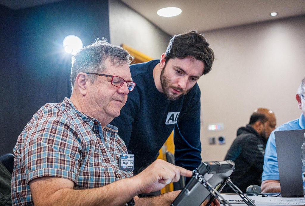 Team member coaching attendee with tablet