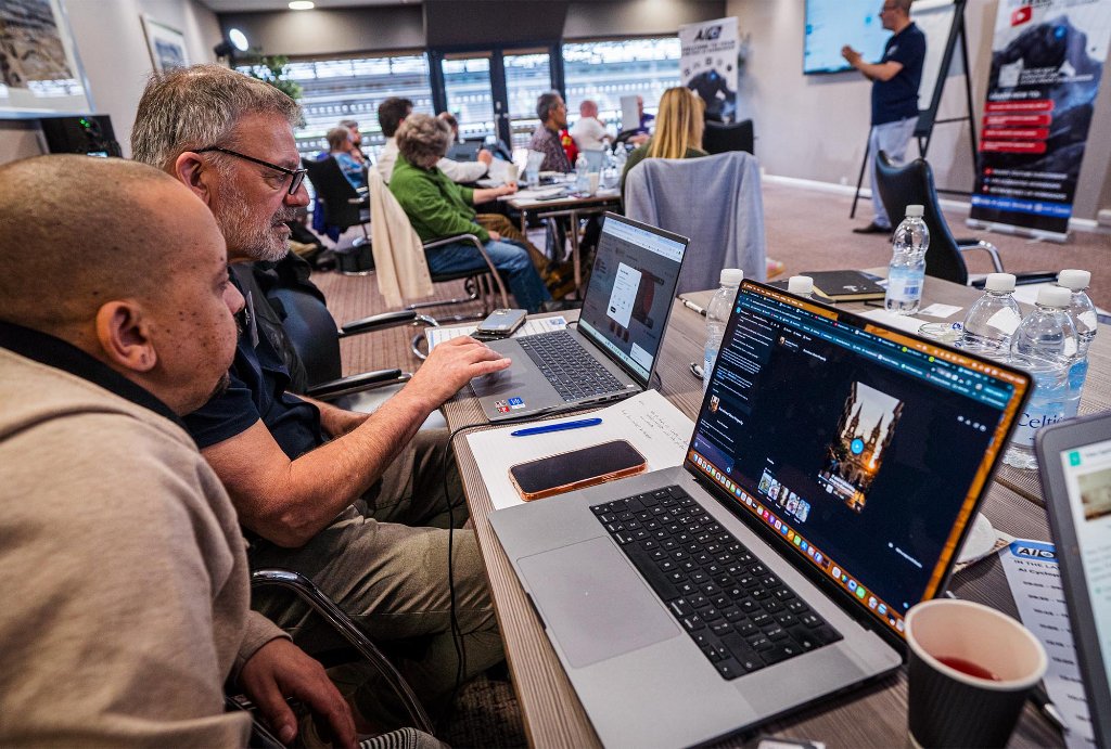 Two attendees collaborating at laptop
